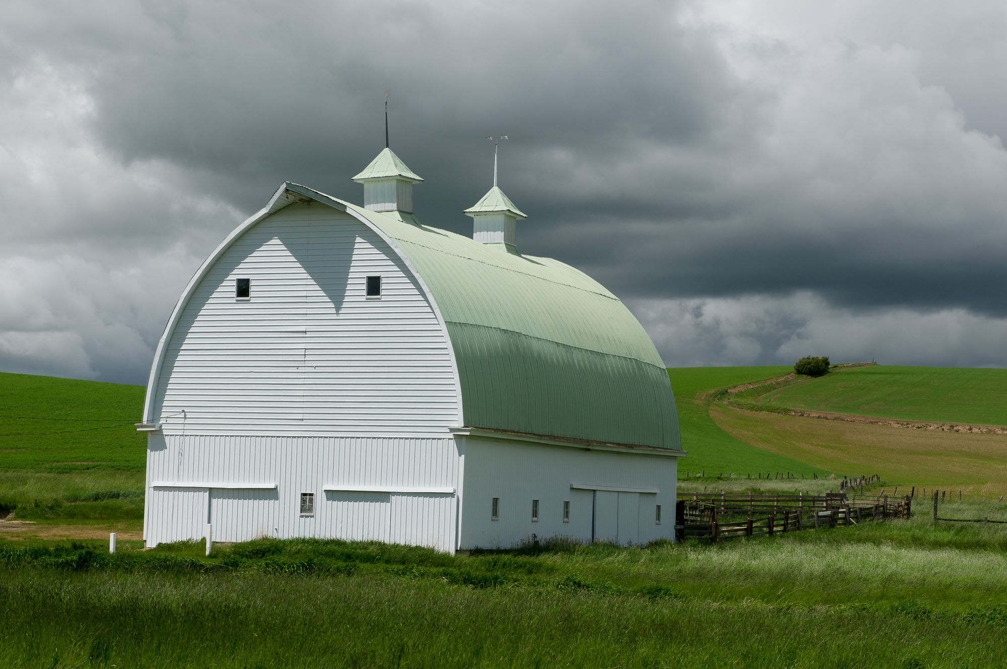 Barbee_080606_3_6168 |  White barn with green roof and two cupolas along Palouse Cove Road, ID. Palouse region of southeast WA and western ID.